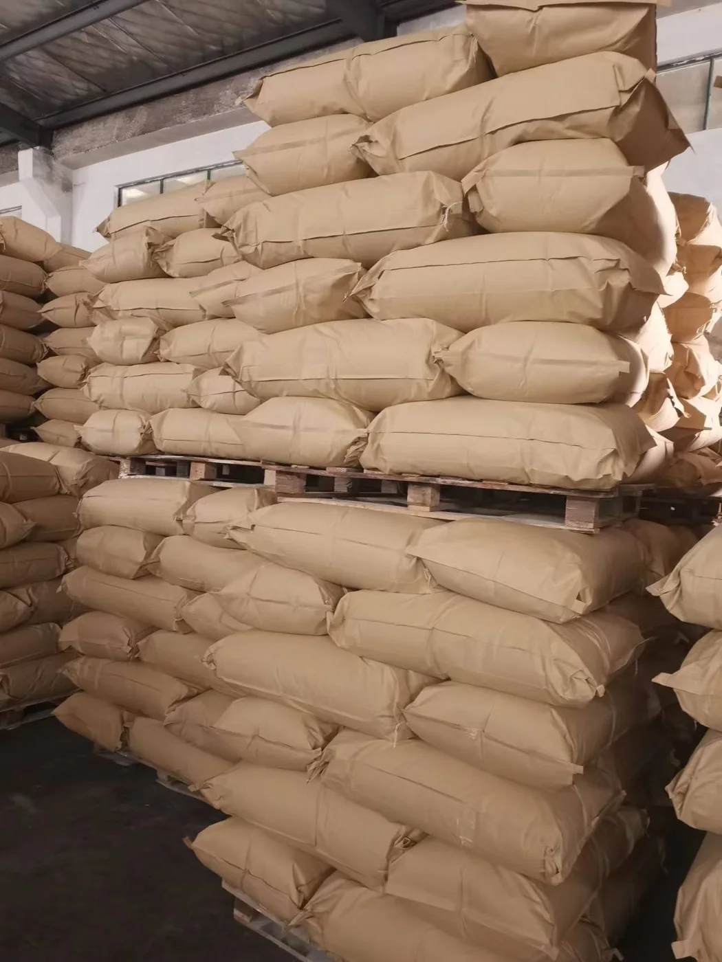 20kg kraft paper bags of wallpaper adhesive powder stacked in warehouse stock for wholesale import and local repacking buyers