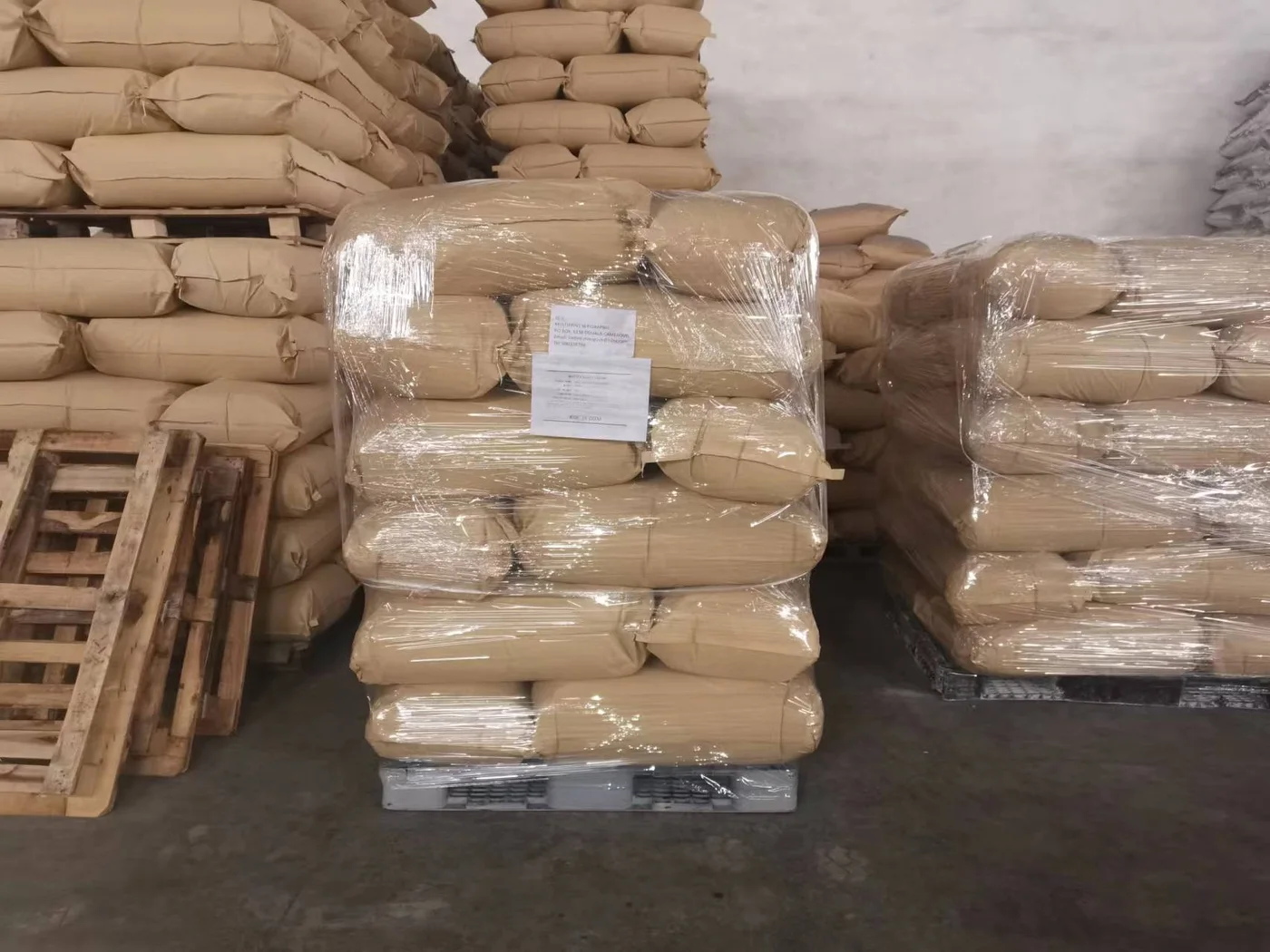 palletized and stretch-wrapped wallpaper adhesive powder bags in warehouse for importer and wholesaler inspection